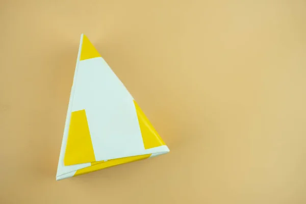 Dreieckige Geschenkschachtel Auf Gelbem Hintergrund — Stockfoto