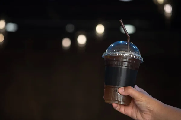 Hand Holding Plastic Cup Iced Black Coffee Blurry Light Coffee — Stockfoto