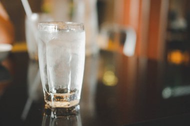 Ice with water in glass on table. Selective focus