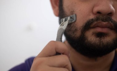 Portrait man with razor in hand while shaving. Men care concept.