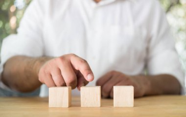 Businessman hand point to wood block on table, empty blank wood block for your design.