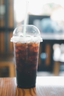 Thai style black coffee in plastic glass on wood table