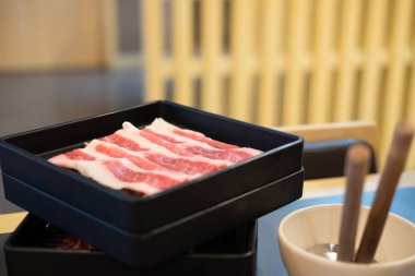 Fresh slice meat in black tray for cooking hot pot. Dinner time