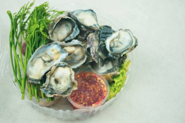 Fresh oyster with herb and spicy sauce in box. Each of the components is separately prepared for mixed when eat.