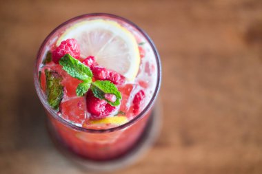 Cold drink black tea of raspberry lemonade with mint in glass. Selective focus