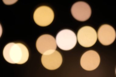 Siyah arkaplandaki altın sarısı bokeh.