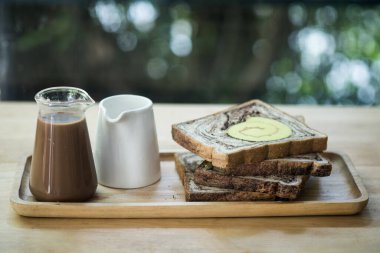 Masada ekmek dilimleri ve sıcak kahve var. Kahvaltı seti.