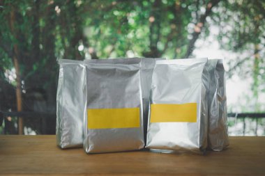 Ahşap masada boş etiketli grup alüminyum torbasını kapat