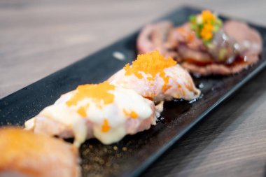 İştah açıcı görünen siyah tepside lezzetli suşi ruloları. Seçici odak