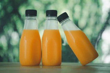 Üç tane taze portakal suyu siyah kapaklı bir şişenin içinde,% 100 hamursuyu.