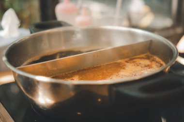 Sıcak tencerede iki farklı şekilde Sukiyaki. Tom yum çorbasını yakın