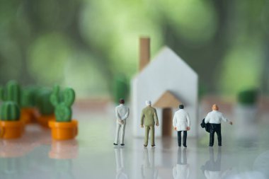 Bulanık minyatür ev geçmişi, gayrimenkul ve iş konsepti olan bir grup minyatür işadamı. Yenileme ve emlak hizmeti kavramı.