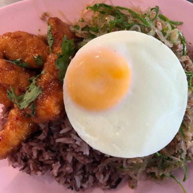 Pirzola ve Tayland yemeği üzerine pembe tabakta güzel kızarmış yumurta. Sağlıklı gıda ve diyet konsepti, seçici odaklanma.