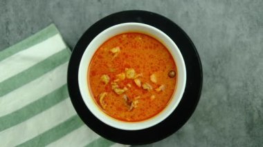 Otantik Tayland mutfağı, dönen beyaz tabakta Penang köri, yakın çekim. Tayland körili kırmızı çorba veya Panaeng körili