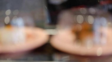 Suşi ve sashimi tabaklarının bulanık hareketi konveyör bandında yuvarlanıyor. Dönen kemerde yiyecek seçenekleri