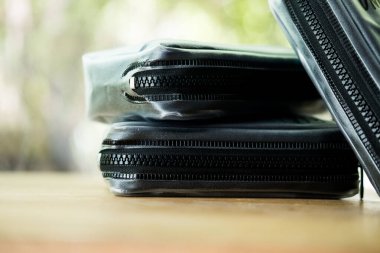 Ahşap masada fermuarlı el çantası.