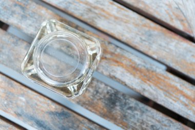 Terastaki ahşap masada baş aşağı duran cam bir kül tablası.