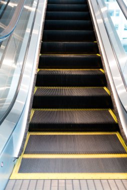 Metal symmetrical escalator steps with yellow safety line