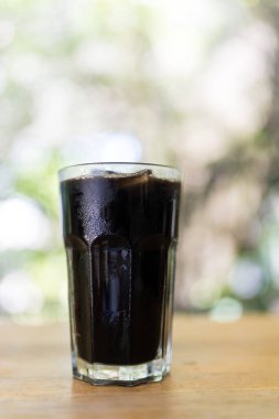 Ahşap masanın üzerindeki buzlu kahveyi doğaya karşı tazeliyorum..