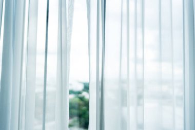 Zarif beyaz perdeler, yumuşak güneş ışığının dingin bir odaya süzülmesini sağlar. Parlak ve huzurlu bir iç atmosfer yaratır..