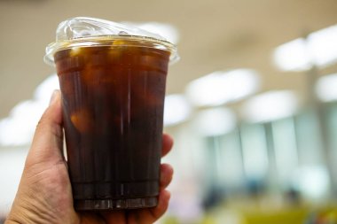 Ofisteki şeffaf bardakta serinletici buzlu americano.