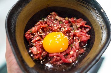 Yemekten önce bir kase çiğ et ve çiğ yumurta karışımı. Malzemelerin zenginliğini ve dokusunu vurguluyor..