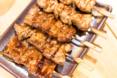 Japon Yakitori şişler üzerinde ızgara yapıyor. Yemek tabağında leziz bir lezzet.