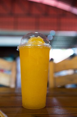 Ahşap masada serinletici bir bardak portakal suyu.