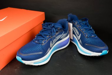 Bangkok, Tayland - 5 Aralık 2025 Nike Vomero 18 Mavi Boşluk Mavi Şimşek Parlak Kırmızı Metalik Gümüş. Siyah arkaplanda ayakkabılar