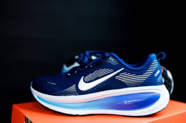 Bangkok, Tayland - 5 Aralık 2025 Nike Vomero 18 Mavi Boşluk Mavi Şimşek Parlak Kırmızı Metalik Gümüş. Siyah arkaplanda ayakkabılar