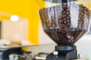 İçinde büyük miktarda kahve çekirdeği olan bir kahve öğütücüsü.