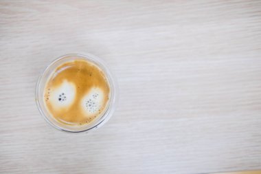 Sıcak kahve fincanı ahşap masanın üstünde.