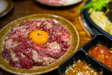 Yumurta sarısı, beyaz susam ve siyah susam soslu marine edilmiş çiğ et. Sukiyaki için hazırlan.