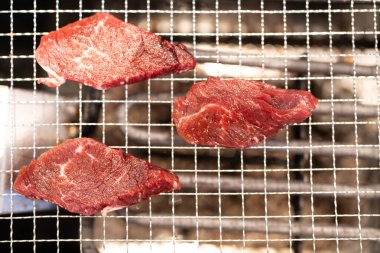 Yakiniku restoranındaki tel örgülü elektrikli ocakta kıyma dilimleri. Üst görünüm