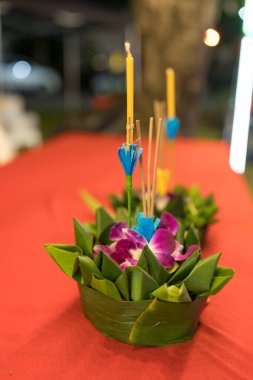 Geleneksel muz yaprağı krathong, Loy Krathong festivali için çiçek sunar..