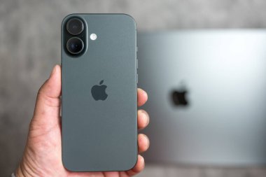 Bangkok, Tayland - 28 Aralık 2025: Yeni iPhone 17 'yi tutan adam. Süper Retina XDR ekranı. Macbook arkaplanlı fotoğraf ve video araçlarına daha hızlı erişim için alüminyum çerçeve ve kamera denetimi