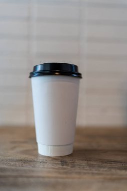 Siyah kapaklı beyaz bir kahve fincanı..