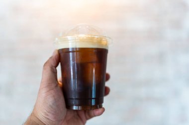 Elindeki buzla bardakta soğuk kahve.