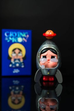 Bangkok, Tayland - 2 Ocak 2026: Mızmız bir bebeğin Uzay Gezgini Pop Mart mağazasından ay serisi figürlerine ağlıyor, sulugöz koleksiyonlar