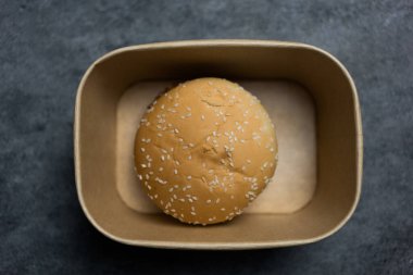 Kahverengi kutuda klasik bir susamlı hamburger ekmeği.