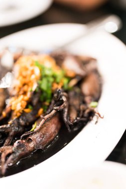 Beyaz tabakta kızarmış siyah mürekkep balığı menüsü, Tayland yemeği..