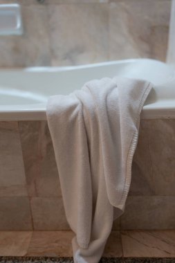 Otelde kullanıldıktan sonra havluyla küvetin kenarından sarkıtılmış.