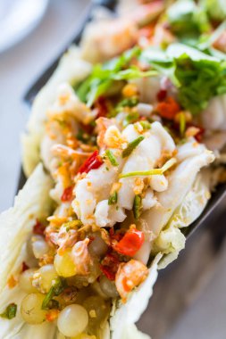 Baharatlı deniz ürünleri salatası, haşlanmış karides ve taze marul yaprağı ve Tayland salatası.