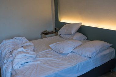 Yatak odasındaki beyaz çarşafı ve kırışık battaniyeyi kapat. Sabah uyandıktan sonra..