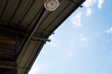 Minimalist, modern bir çatı köşesi ve açık mavi gökyüzü.