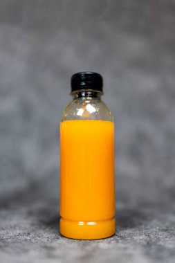 Siyah kapaklı bir şişe taze portakal suyu.