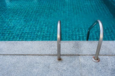 Yüzme havuzu paslanmaz çelik merdiven merdiveni ve mavi su