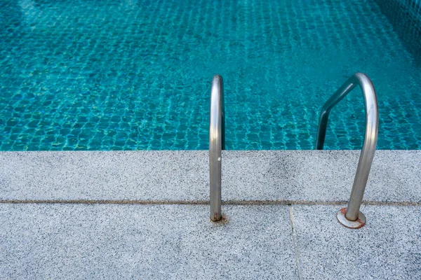 Yüzme havuzu paslanmaz çelik merdiven merdiveni ve mavi su