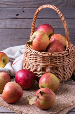 Ahşap arka plan, dikey bir sepet içinde kırmızı elmalar