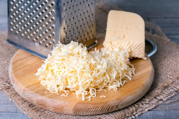 Grated cheese with grater — Stock Photo, Image